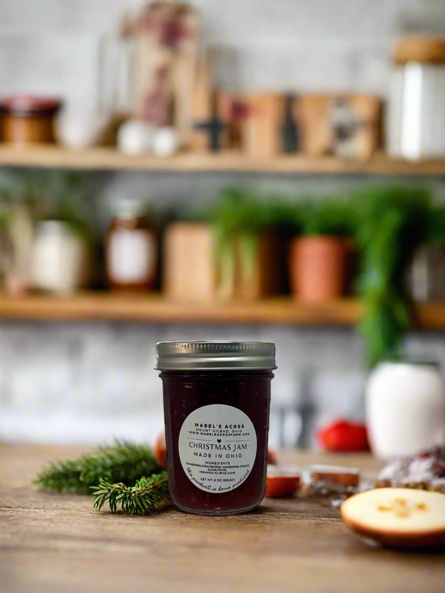 Jar of homemade Christmas Jam from Mabel’s Acres, made with fresh cranberries, strawberries, raspberries, and oranges in small batches.