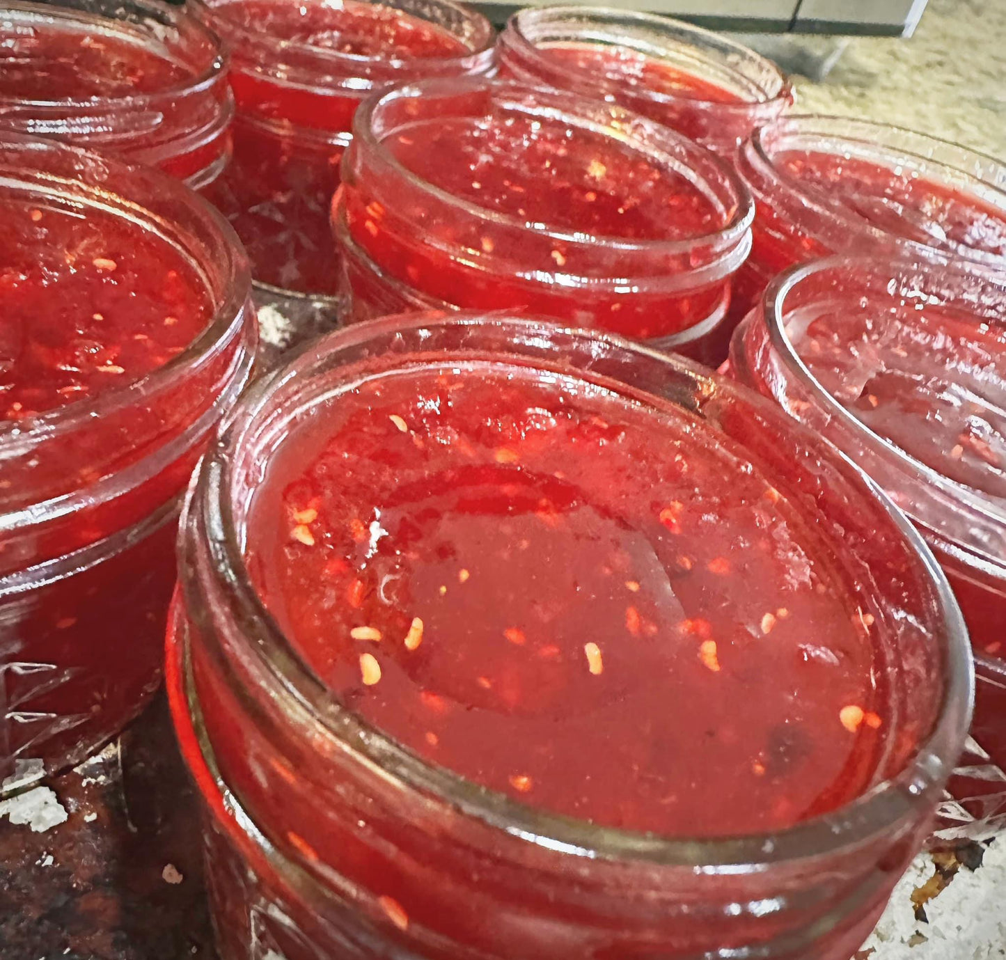 Jar of homemade Christmas Jam from Mabel’s Acres, made with fresh cranberries, strawberries, raspberries, and oranges in small batches.