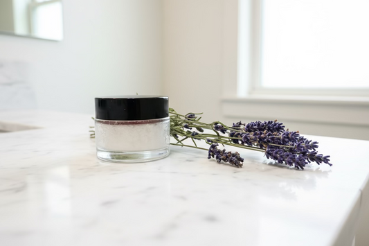 Glass jar with black lid and lavender flowers on a white background